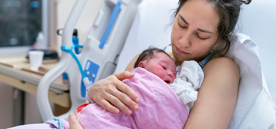 Woman with baby after giving birth in hospital