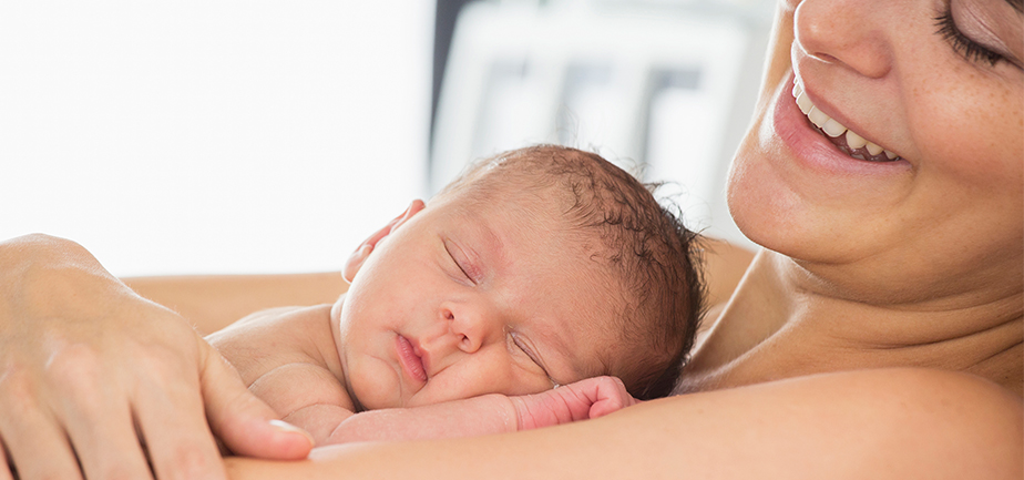 baby on mother with mother smiling