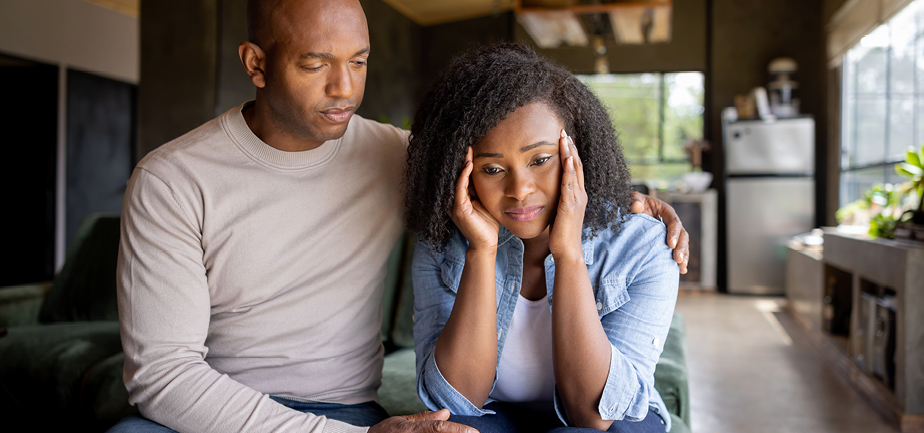 Loving husband consoling his sad wife at home.