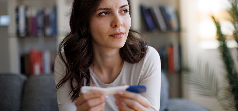 Thoughtful young woman waiting for pregnancy test result.