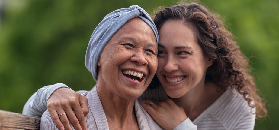 An adult daughter embraces her senior mother