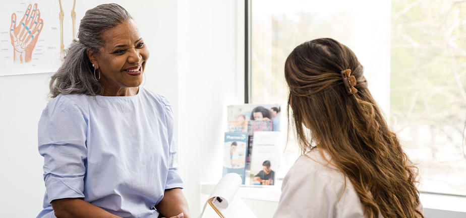 A female doctor talks with her senior adult patient.