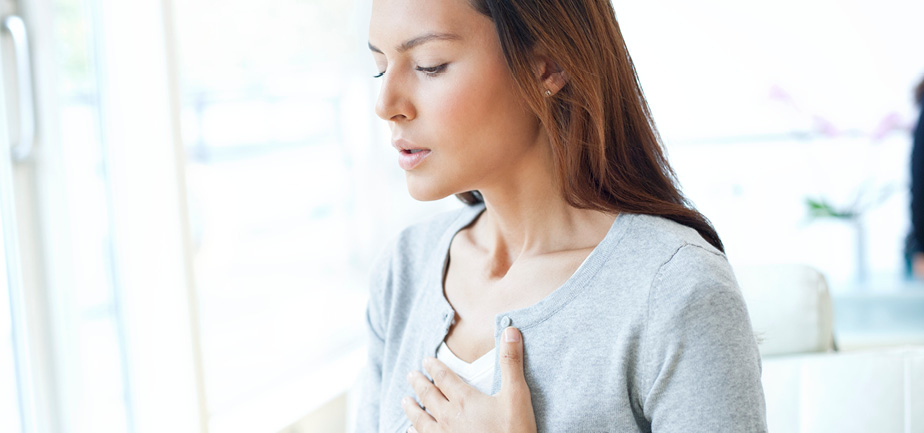 Young woman with hand on chest.