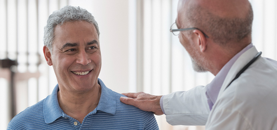 Doctor using digital tablet and talking to patient in office