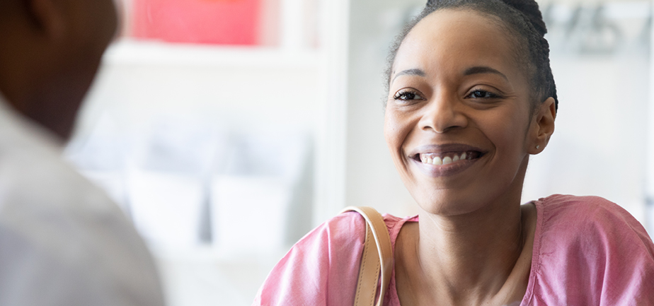 Mature woman happy and smiling while having a conversation with her pharmacist.