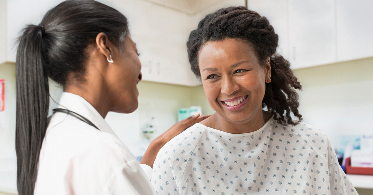 Doctor comforting female patient in office