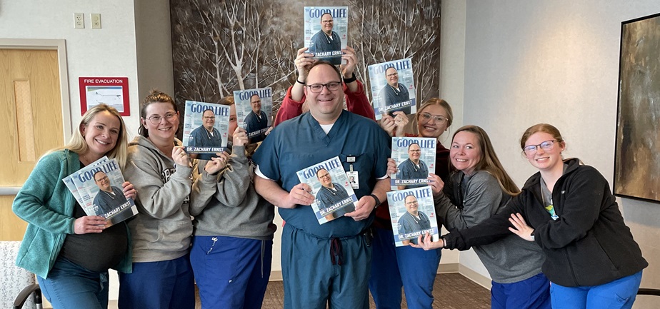 Dr. Zachary Ernst is surrounded by his team at Essentia Health-Fargo as they show off The Good Life magazine featuring Dr. Ernst on the cover