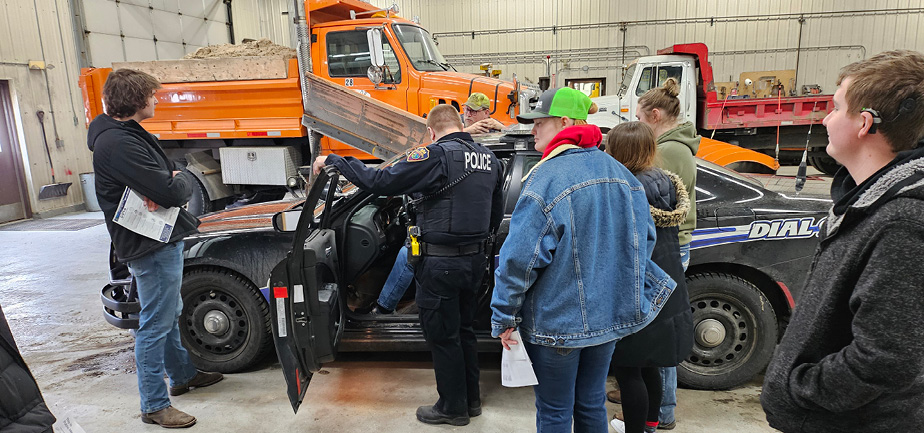 high school students exploring a police car