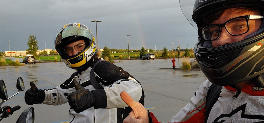 two people outside on motorcycles