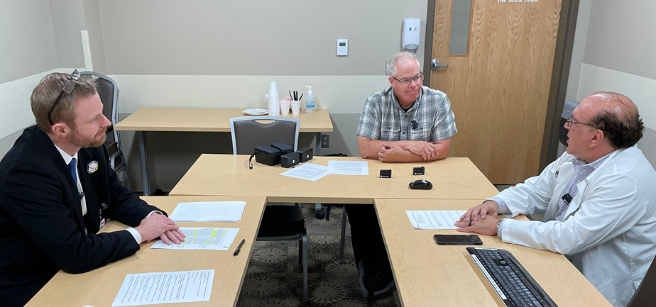three men sitting around a table for an interview