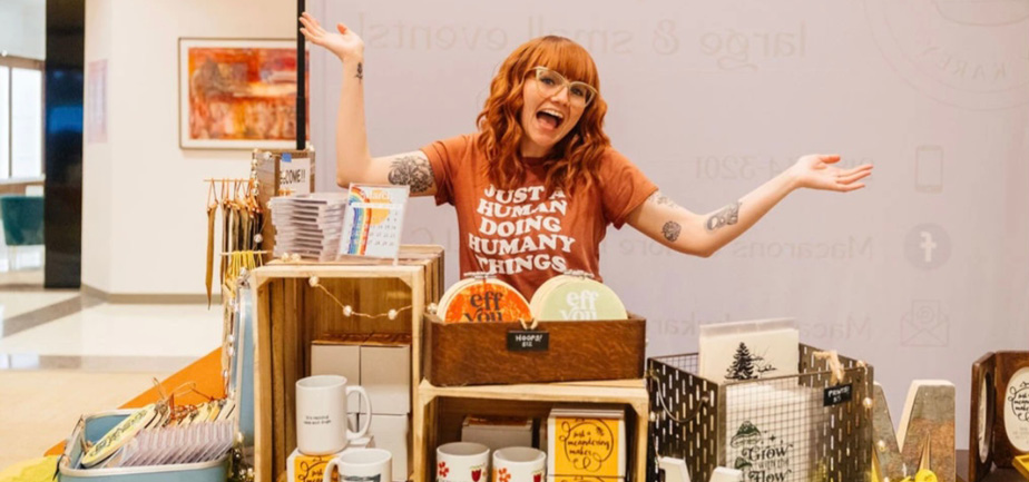 woman with red hair smiling at a craft booth