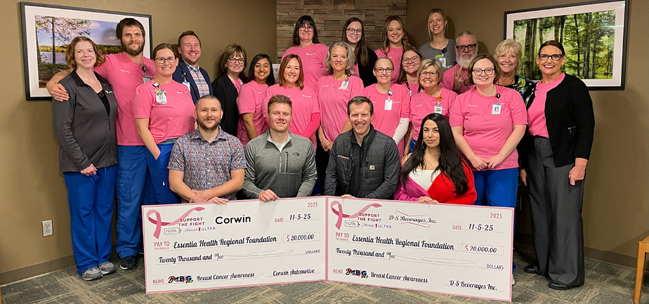 Large group of people smiling and standing in front of two checks totaling $40,000.