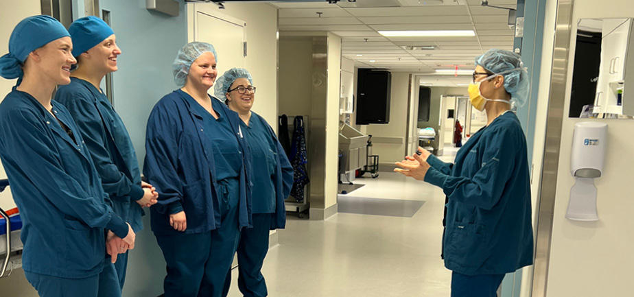 group of women in scrubs standing in a hallway talking