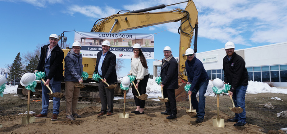 group of people standing outside with shovels and dirt and hard hats