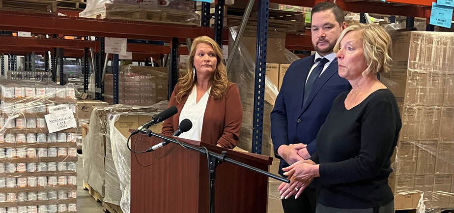 two women and one man standing behind a podium