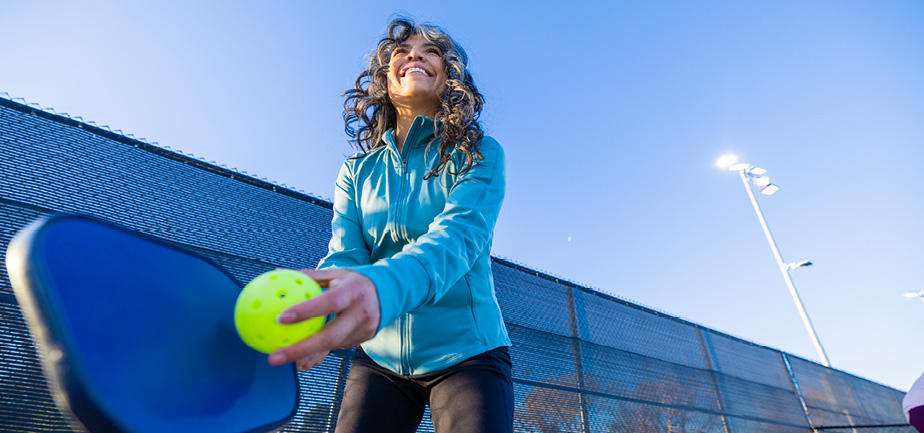 woman in blue top playing pickleball