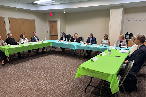 group of people seated around a u-shaped table