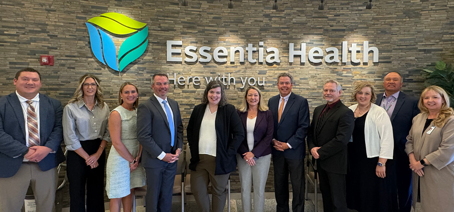 group of similing people standing in front of a sign that says Essentia Health