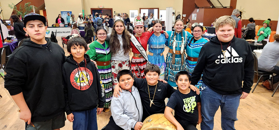 large group of Indigenous youth gathered together, smiling