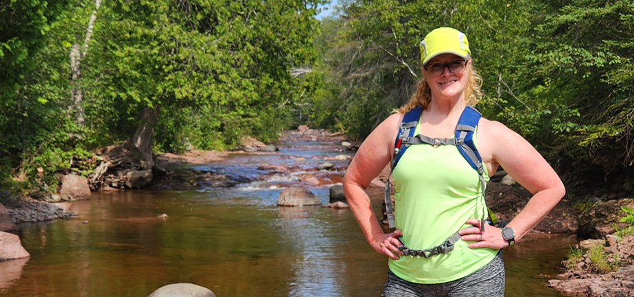 woman standing outside in front of a stream