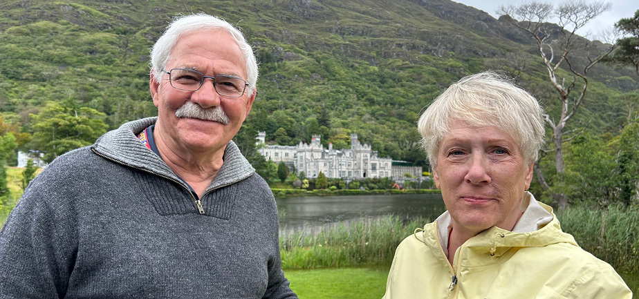 older man and woman standing next to each other outside