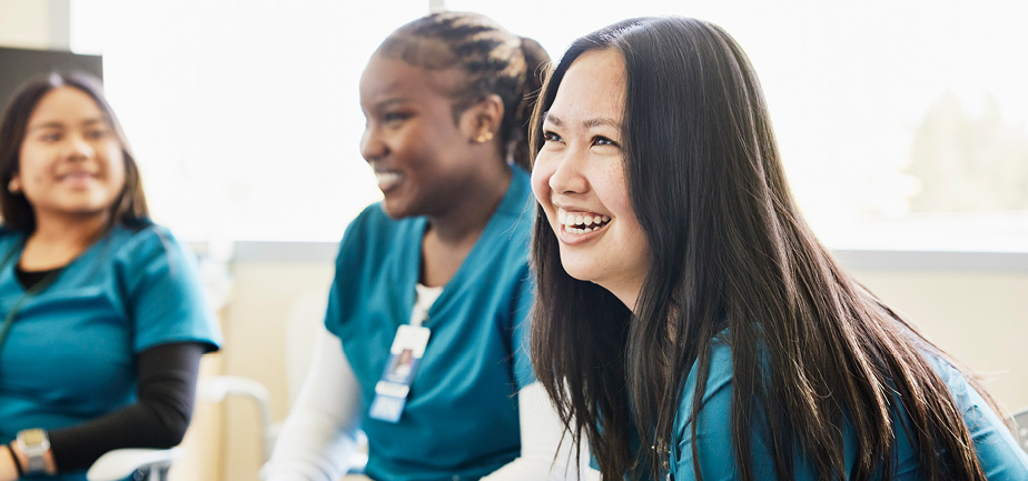 three female nursing students sitting in a group and smiling