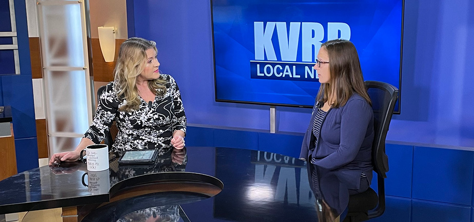 Two women chatting at a desk on live TV