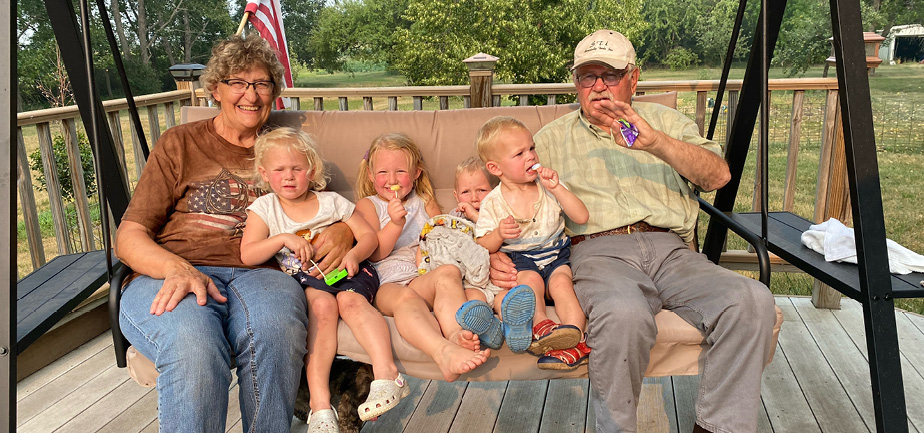 grandparents with four grandchildren on a swing