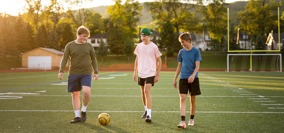 three boys on a soccer field