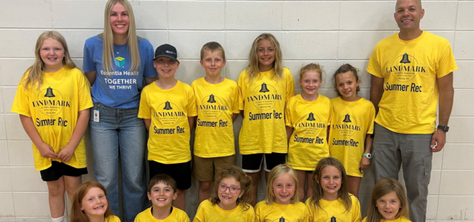 two adults with a group of children smiling for a photo