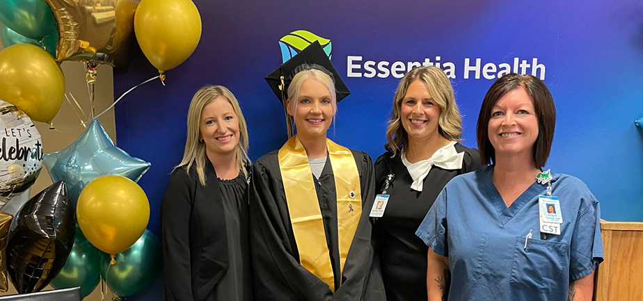 four women standing in a group, smiling