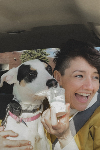 a woman smiling with her dog in her lap