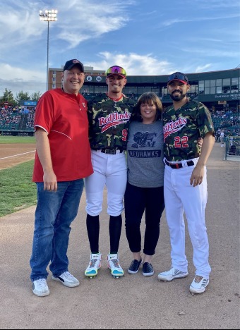 family standing in baseball field