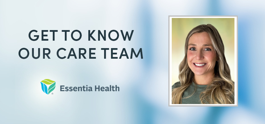 Woman in a green shirt with long hair smiling at camera.