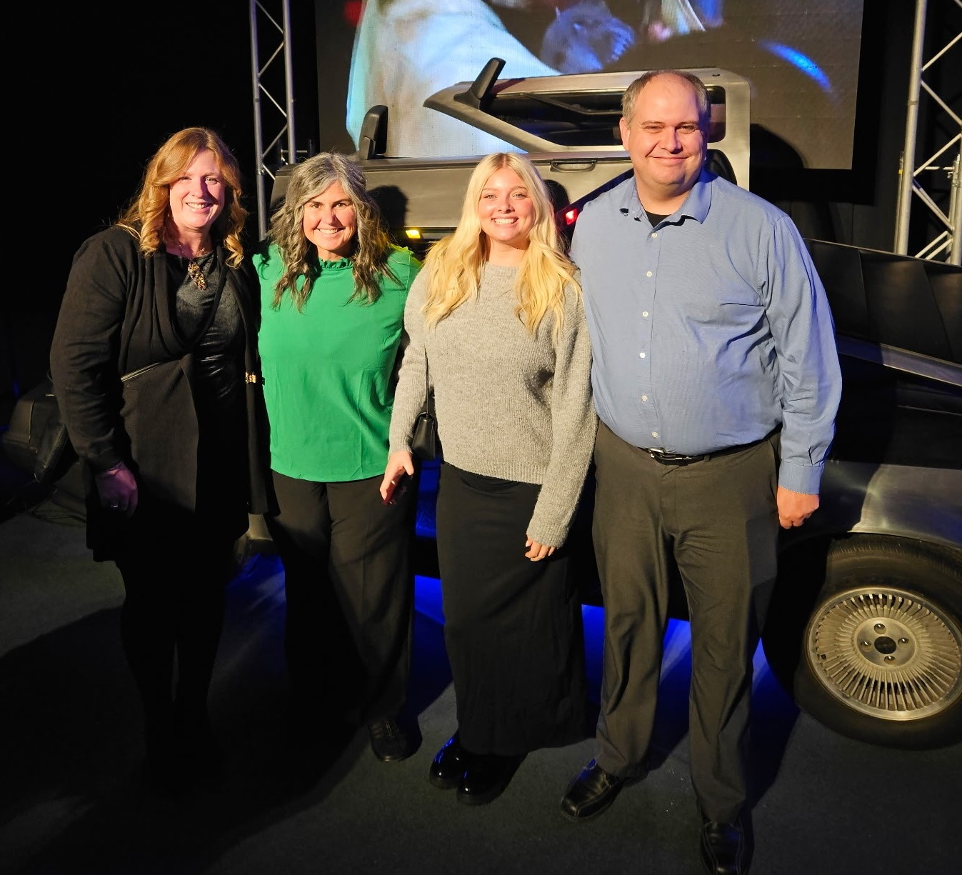 a man and three women standing together and smiling