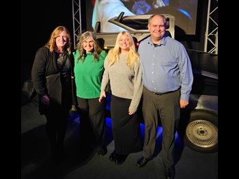 a man and three women standing together and smiling