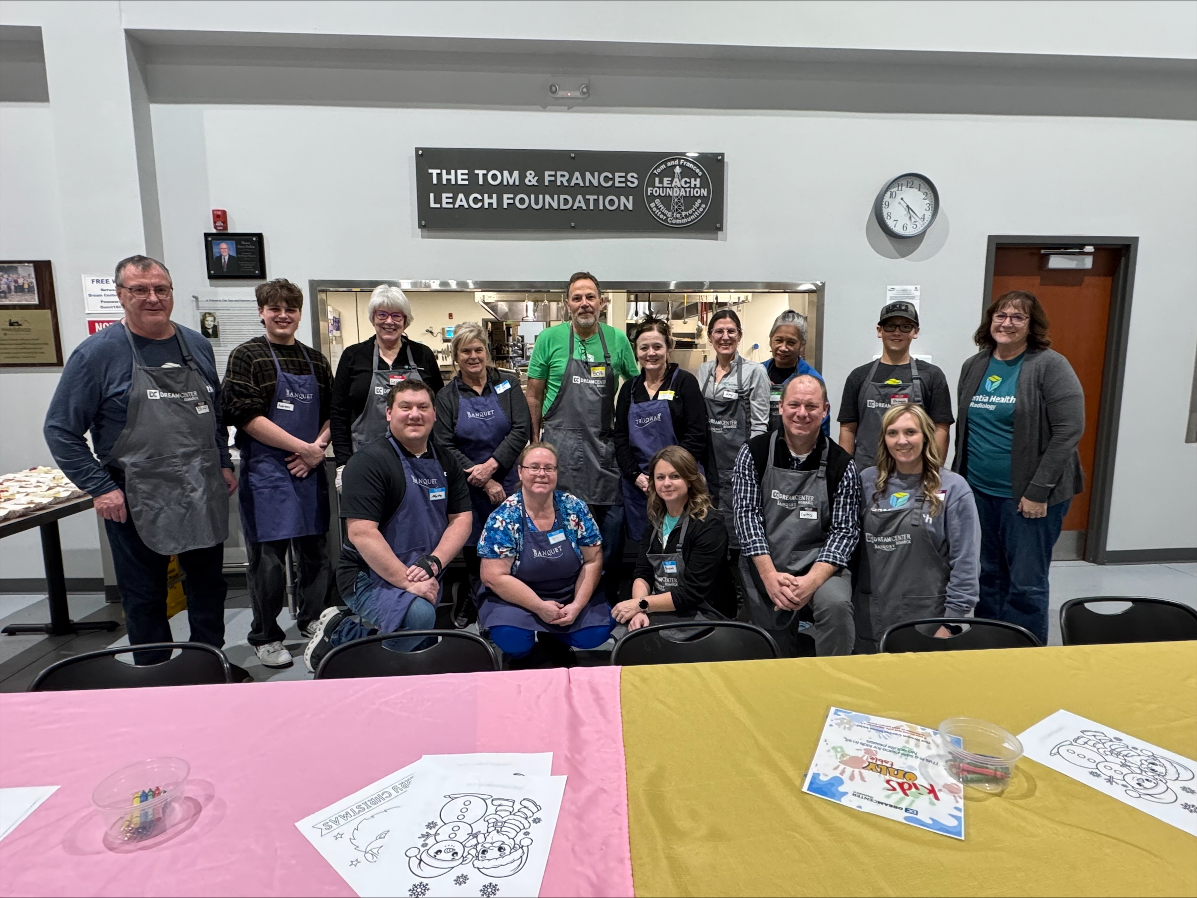 a group of men and women in aprons, smiling together