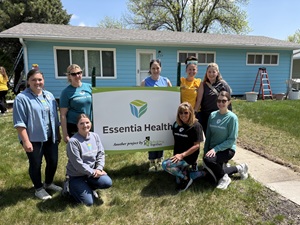 Essentia employees and others with a huge Essentia banner